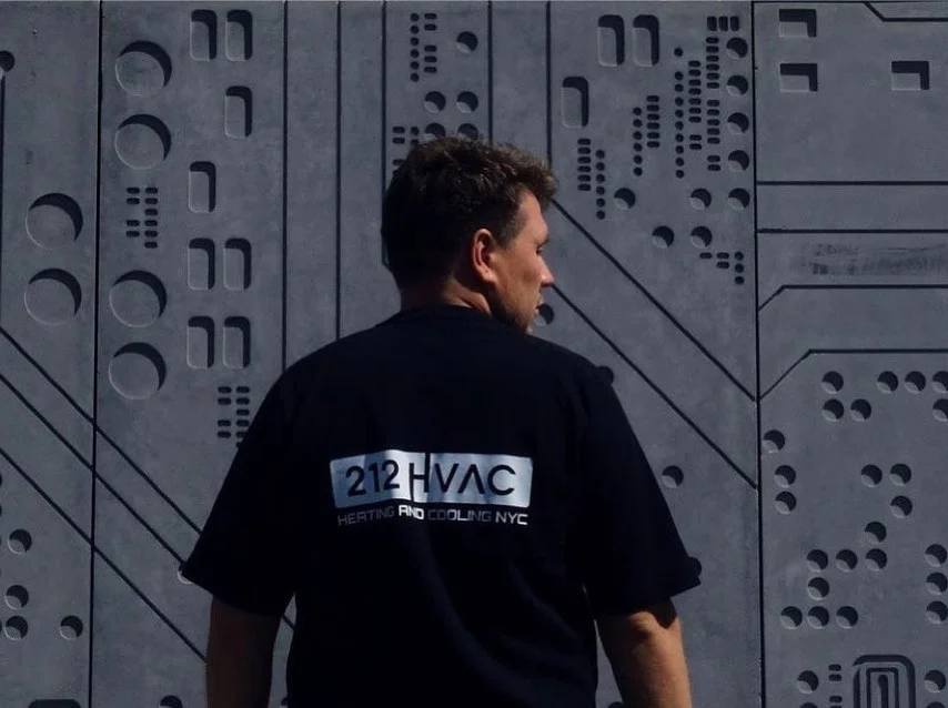 212 HVAC technician with tools beside the service van.
