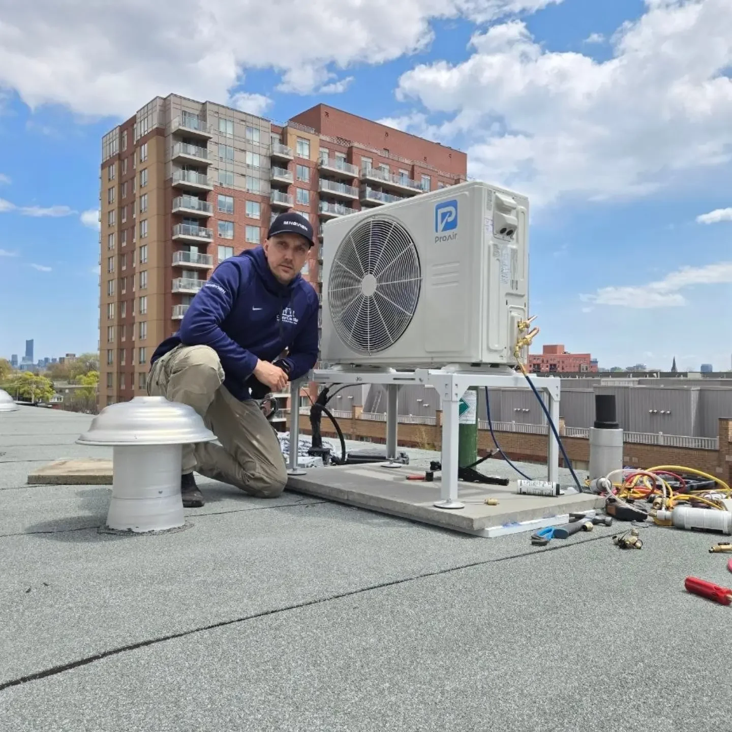 Cozy Castle technician beside a ProAir rooftop installation.